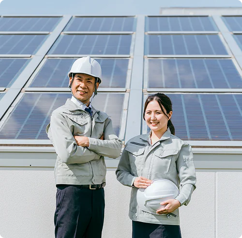 太陽光発電設備の前に立つスタッフ